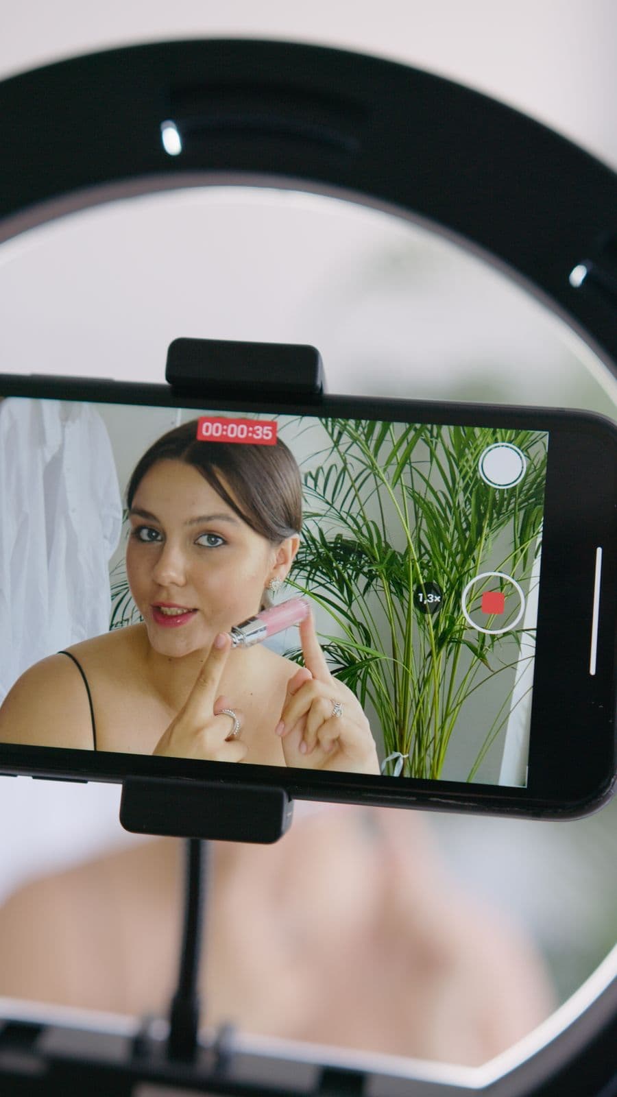 Beauty creator filming a makeup tutorial with a phone and ring light