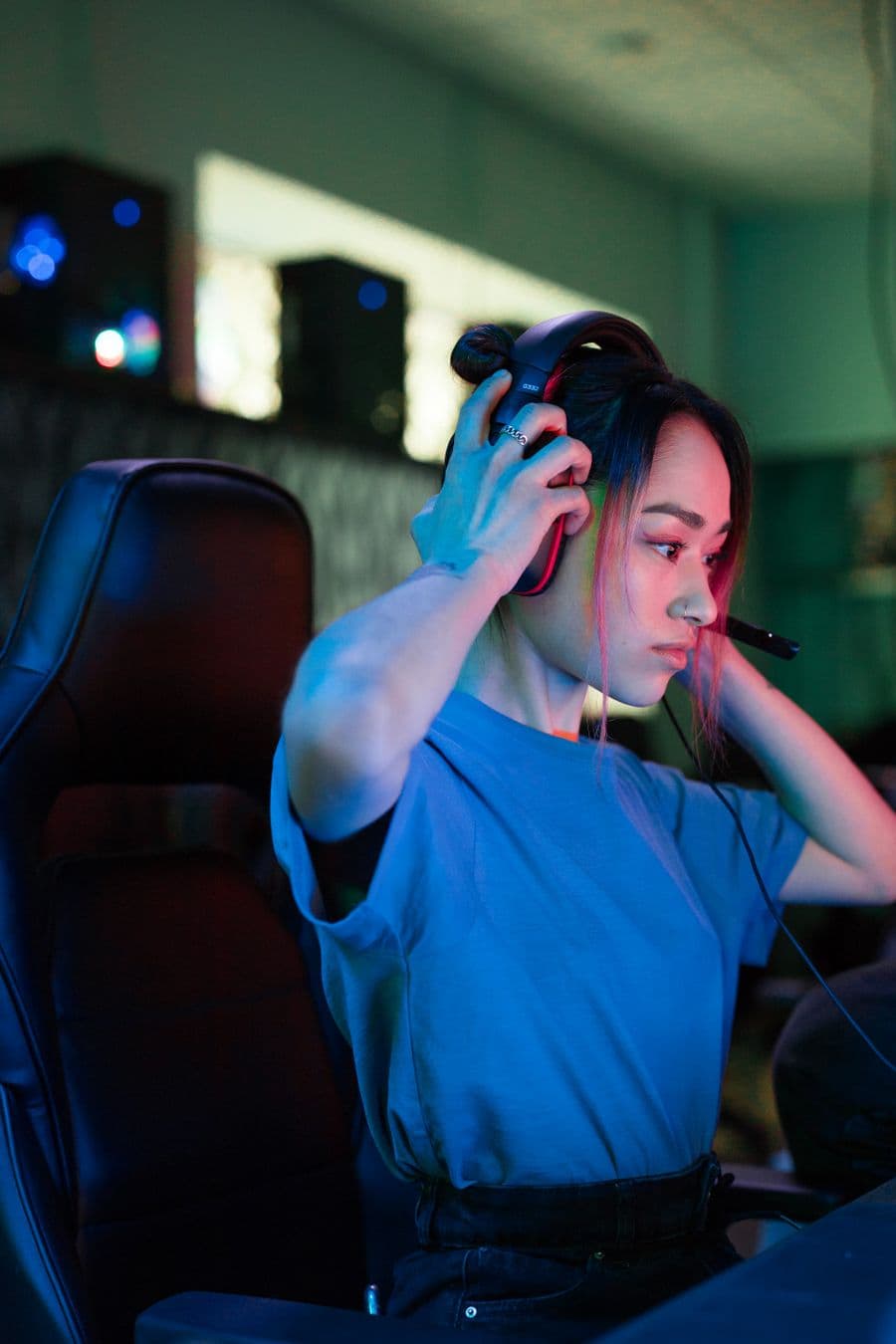 Gaming creator putting on a headset in a colorful streaming setup