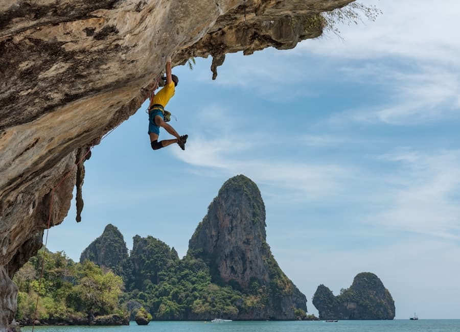 A climber scaling a mountain above the water